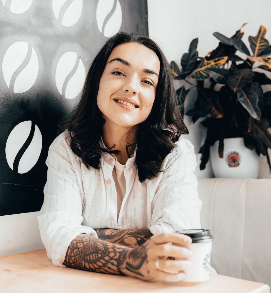 Alex Hindley smiling at a café table